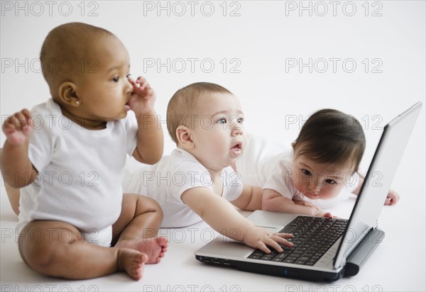 Babies playing with laptop