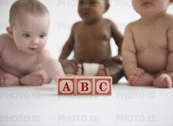 Babies sitting with alphabet blocks