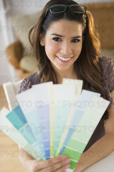 Hispanic woman holding paint swatches