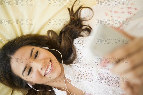 Hispanic woman listening to mp3 player
