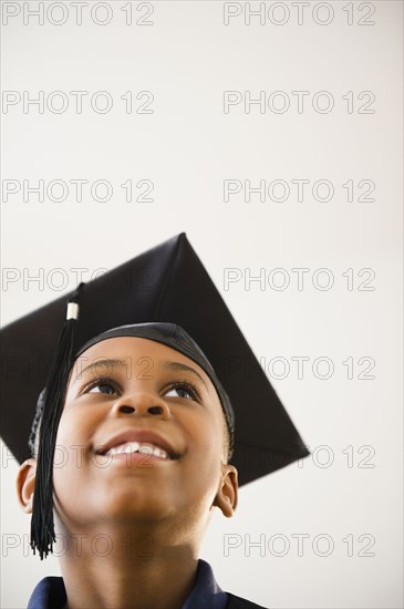 Smiling Black boy in graduation cap