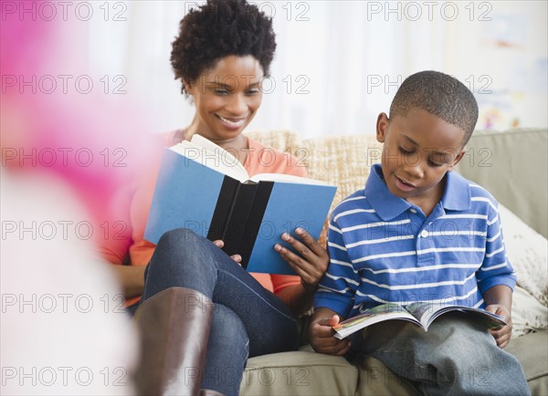 Black mother and son reading together