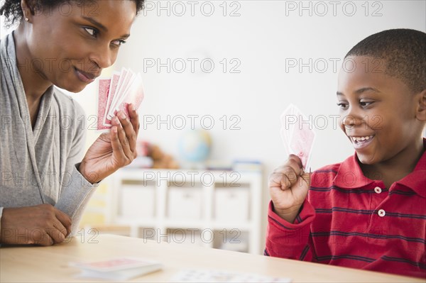 Black mother and son playing cards together