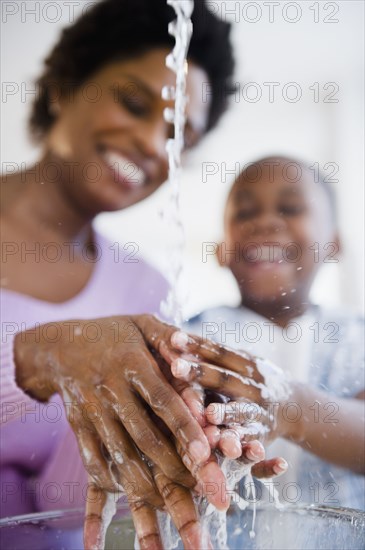 Black mother and son washing hands