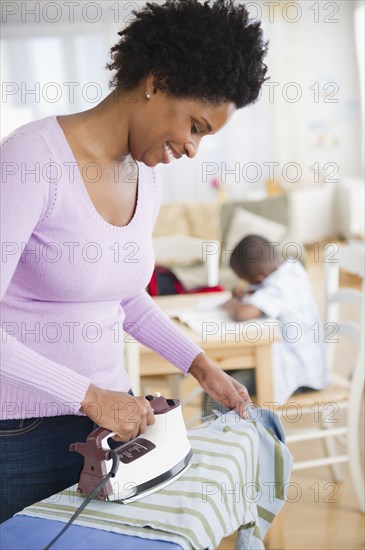 Black woman ironing shirt