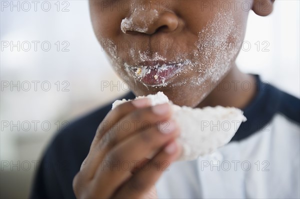 Messy Black boy eating donut