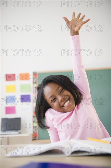 Black student raising arm answering a question