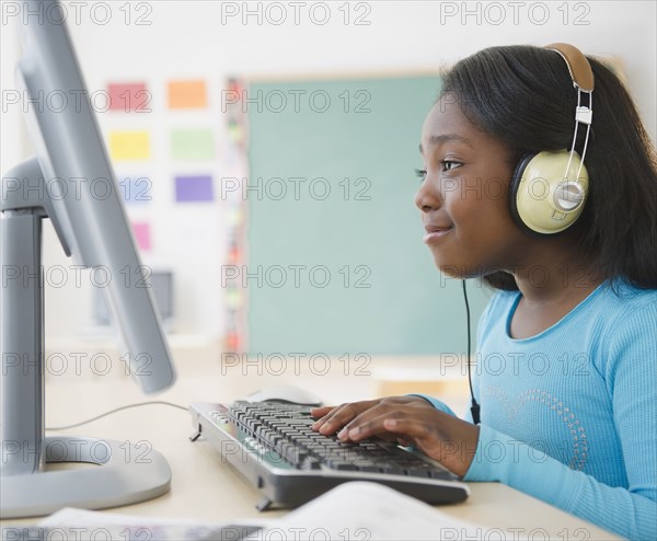 Black student using computer in classroom