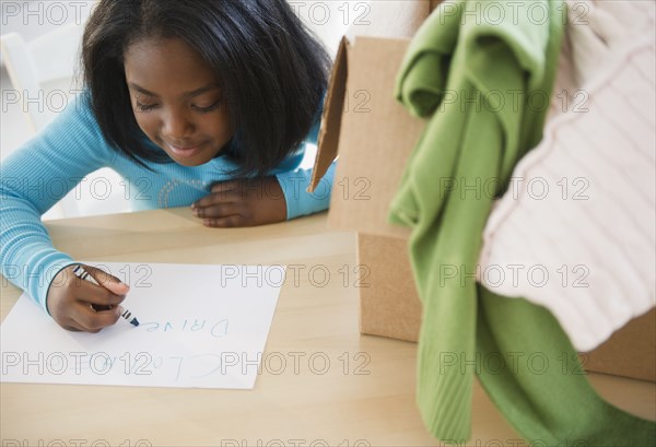 Black girl donating clothing to charity