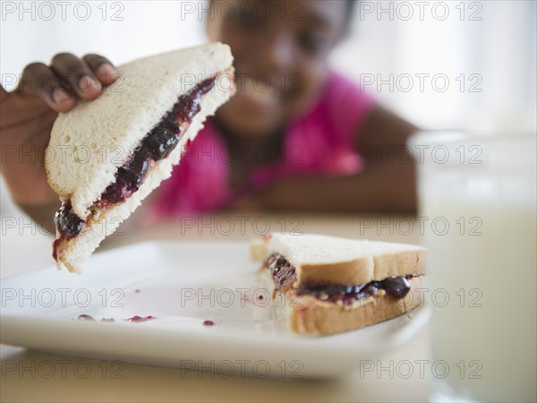 Black girl eating peanut butter and jelly sandwich