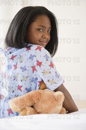 Black girl sitting on hospital bed