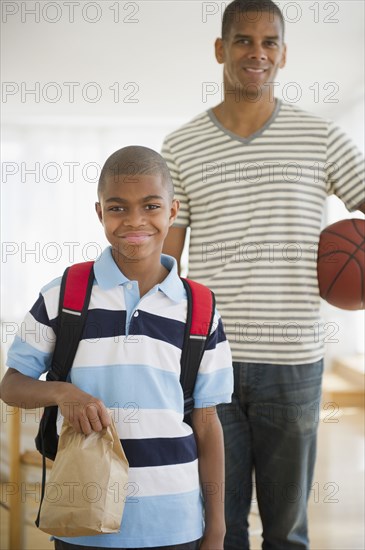 African American boy holding lunch sack