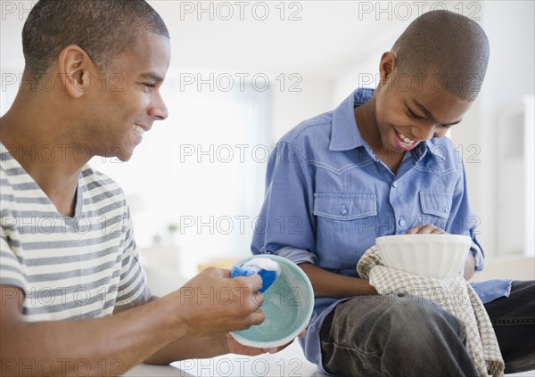 Father and son washing dishes