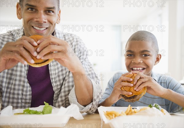 Father and son eating hamburgers