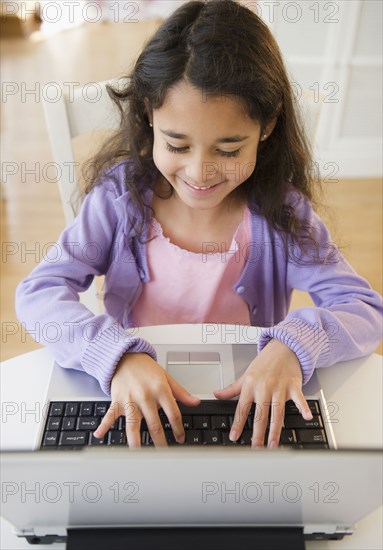 Mixed race girl using laptop