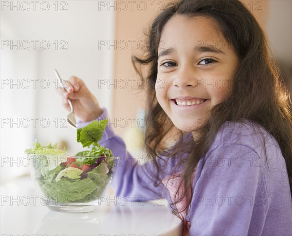 Mixed race girl eating salad