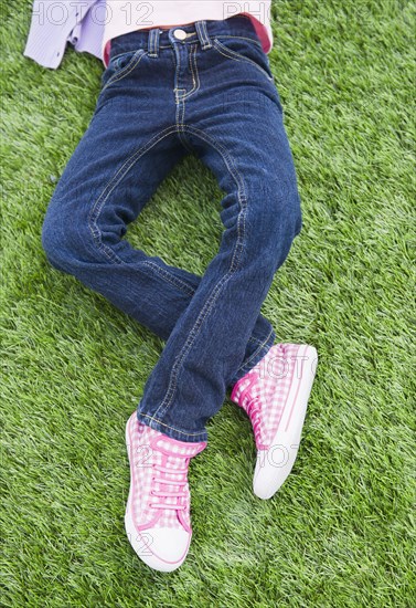 Mixed race girl laying on grass