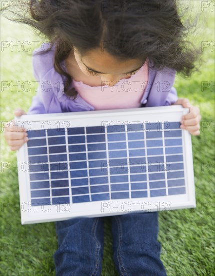 Mixed race girl holding solar panel