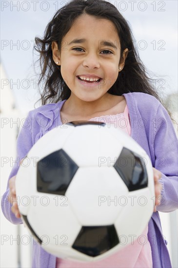 Mixed race girl holding soccer ball