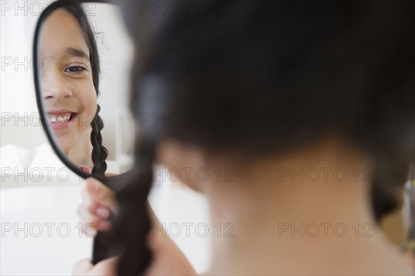 Mixed race girl looking in mirror