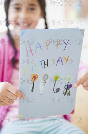 Mixed race girl holding birthday card