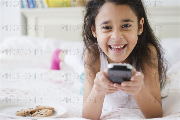 Mixed race girl using remote control