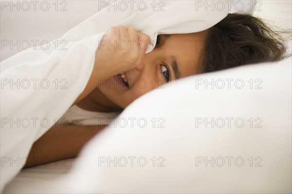 Mixed race girl underneath sheet