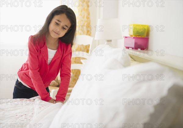 Mixed race girl making bed