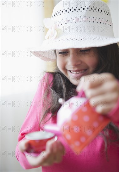 Mixed race girl pouring tea