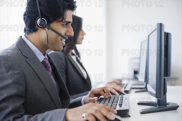 Mixed race business people using computers