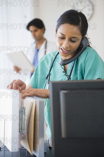 Mixed race nurse talking on telephone