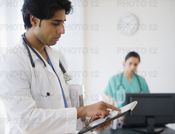 Mixed race doctor using digital tablet