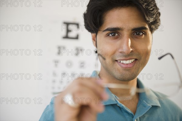 Mixed race man taking of eyeglasses