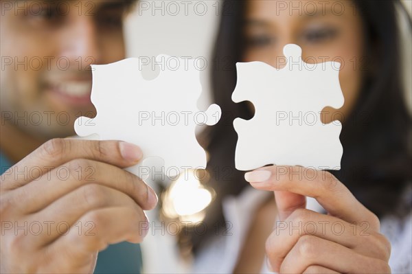 Mixed race couple holding puzzle pieces