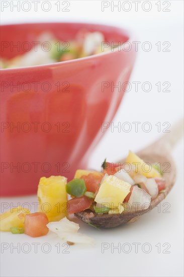 Spoonful of salsa next to bowl
