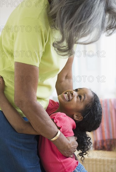 African American grandmother and granddaughter hugging