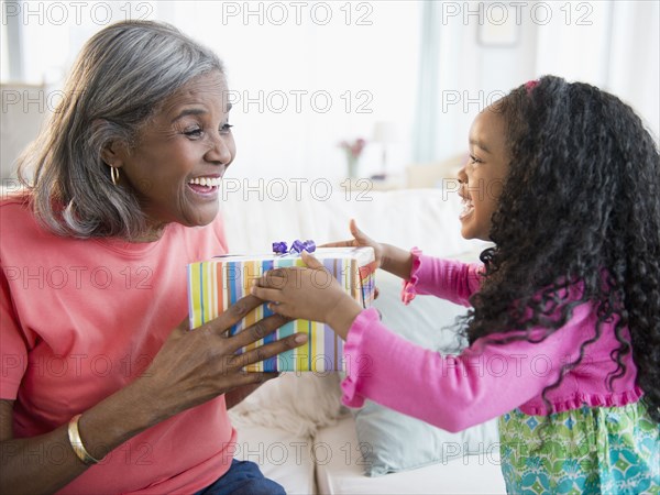 African American girl giving gift to grandmother