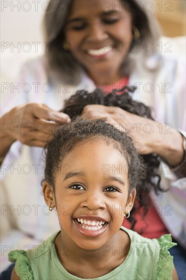 African American woman fixing granddaughter's hair