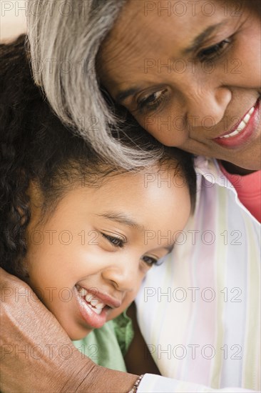 African American grandmother and granddaughter hugging