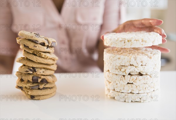 Cape Verdean woman stacking cookies and rice cakes