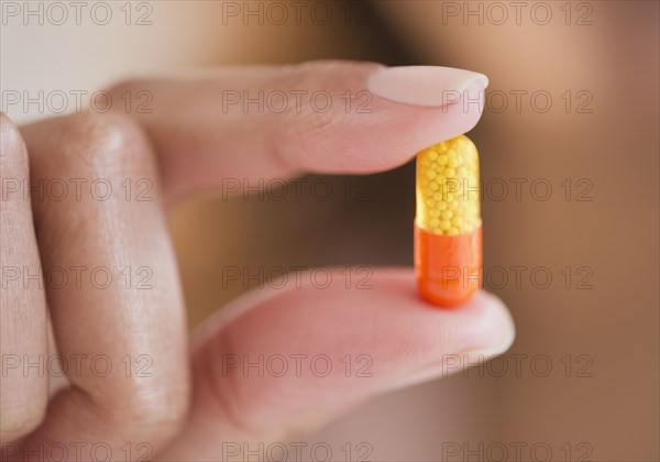 Cape Verdean woman holding pill capsule