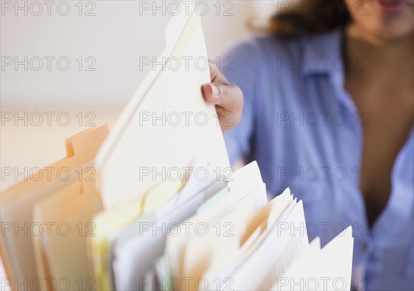 Cape Verdean woman picking up file folder