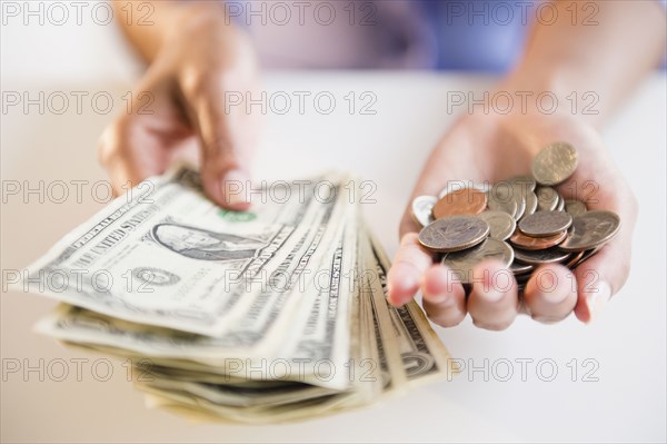 Cape Verdean woman holding dollar bills and coins