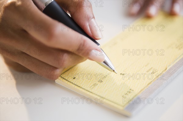 Cape Verdean woman writing a check