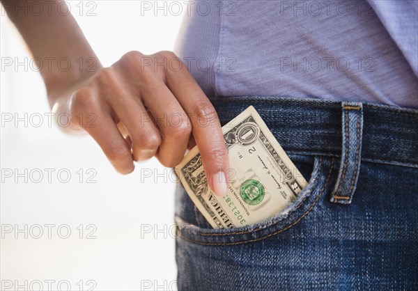 Cape Verdean woman taking dollar bill from pocket