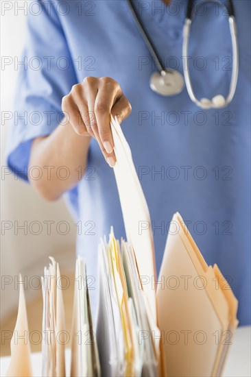 Cape Verdean woman picking up a file folder