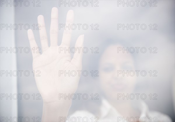 Cape Verdean woman putting hand on window