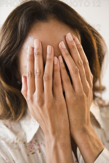 Cape Verdean woman with hands over face