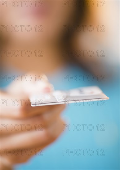 Cape Verdean woman holding out credit card