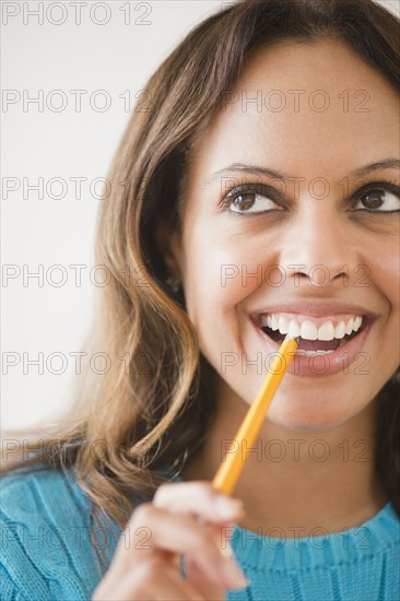 Cape Verdean woman biting pencil